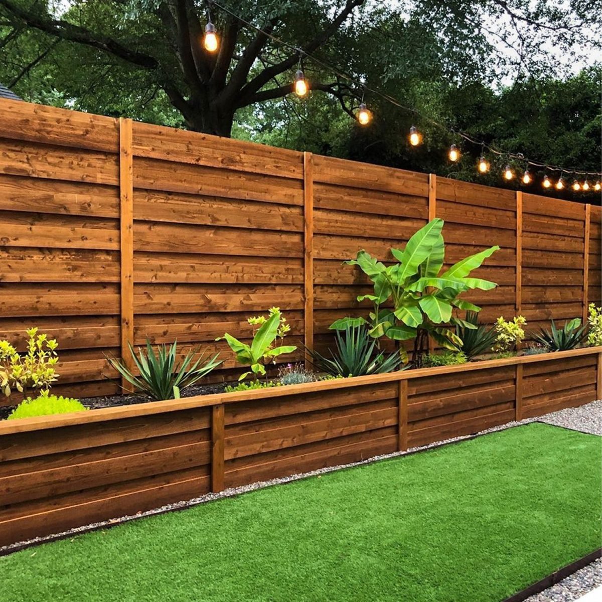 Horizontal timber fence with backyard landscaping